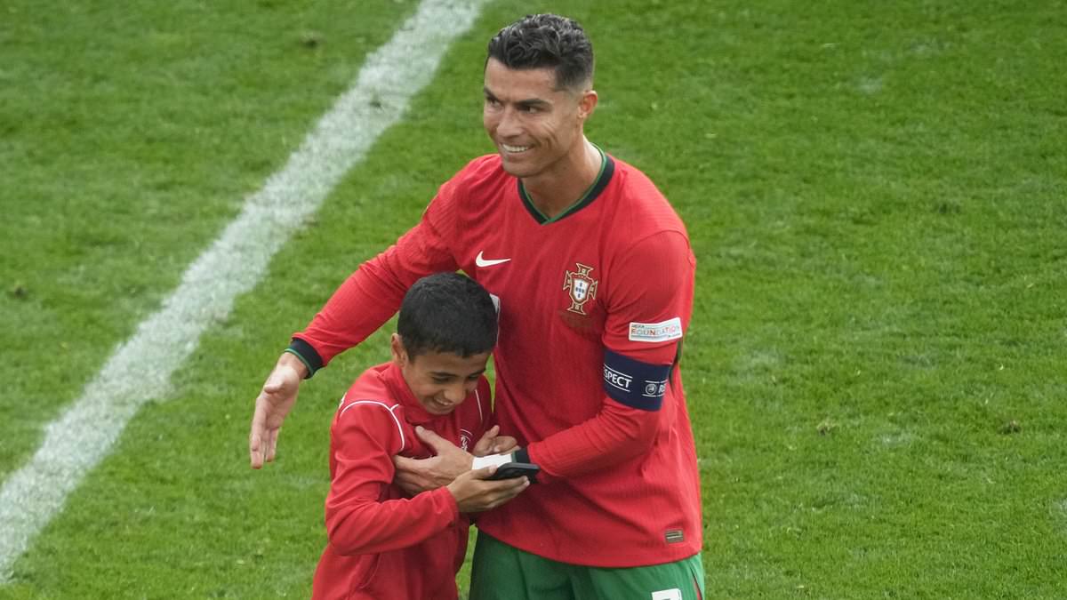 UEFA to investigate SIX pitch invasions during Portugal's win over Turkey after selfie-hunting fans targeted Cristiano Ronaldo after he took picture with young fan... as Roberto Martinez slams culprits